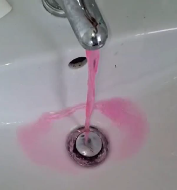 Pink water coming out of a tap