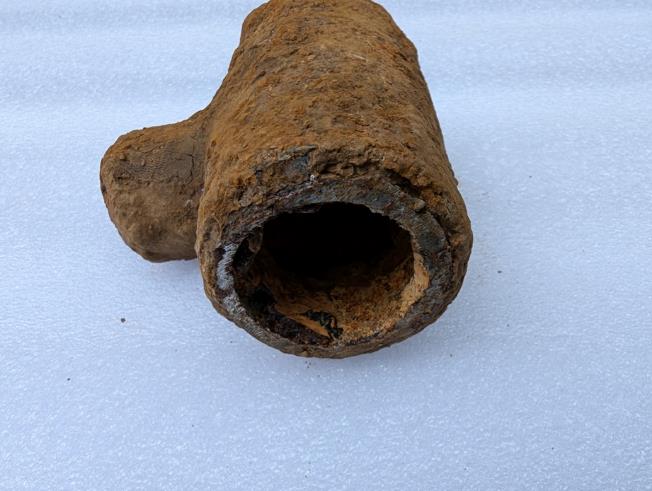 Section of a water pipe which was suspected of containing lead, the section appears relatively small and appears heavily corroded on the outside.